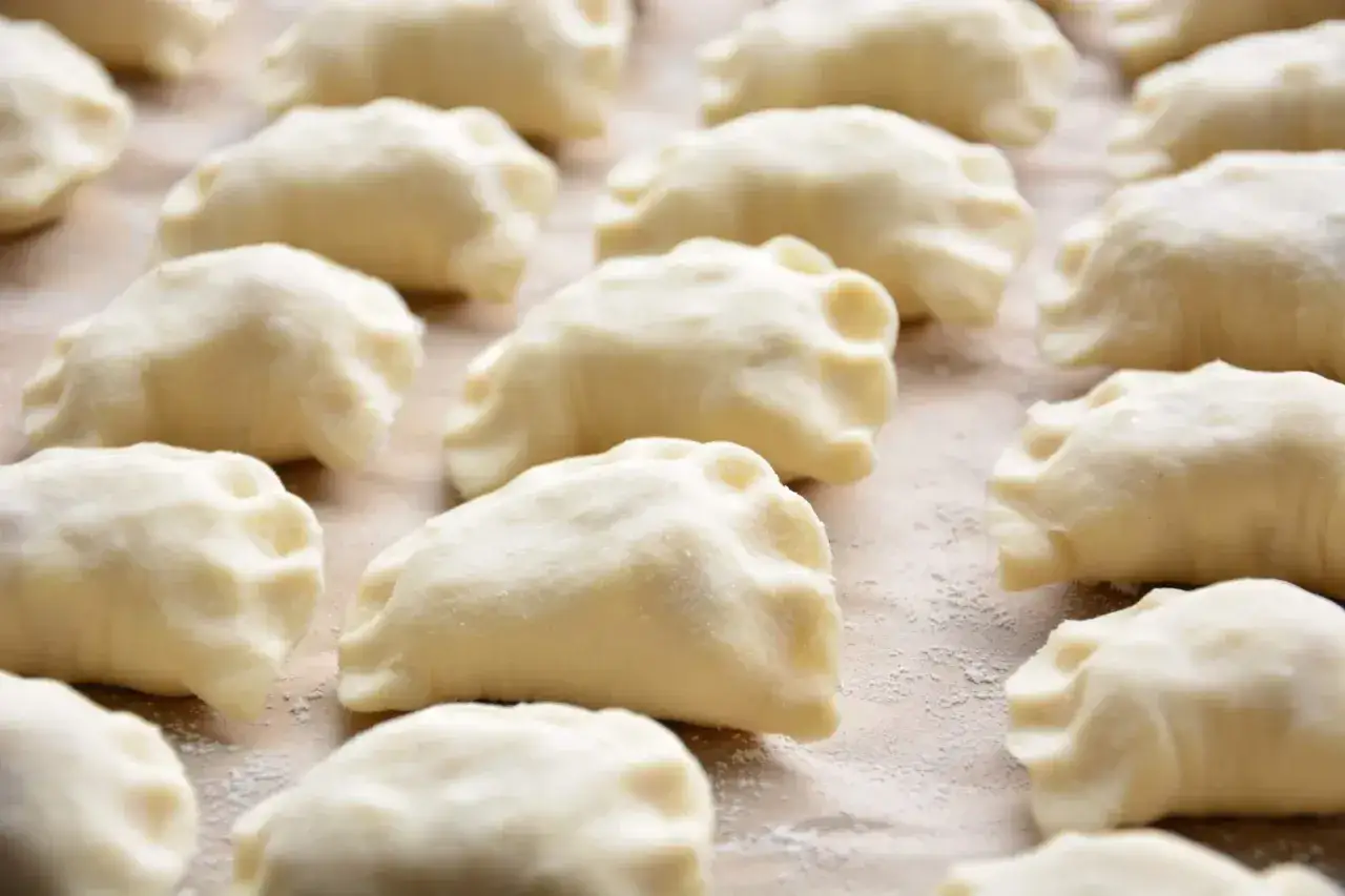 Gotowe do gotowania pierogi, które są efektem przepisu na miękkie ciasto na pierogi.