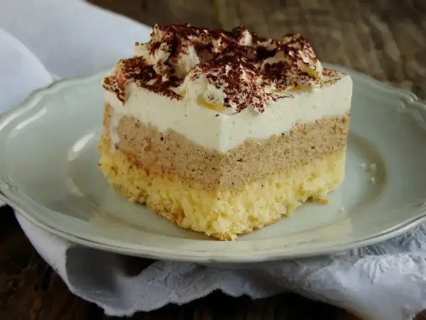Przepis na ciasto cappuccino na biszkopcie. Puszysty biszkopt, kremowa warstwa kawowa i bita śmietana z kakao.
